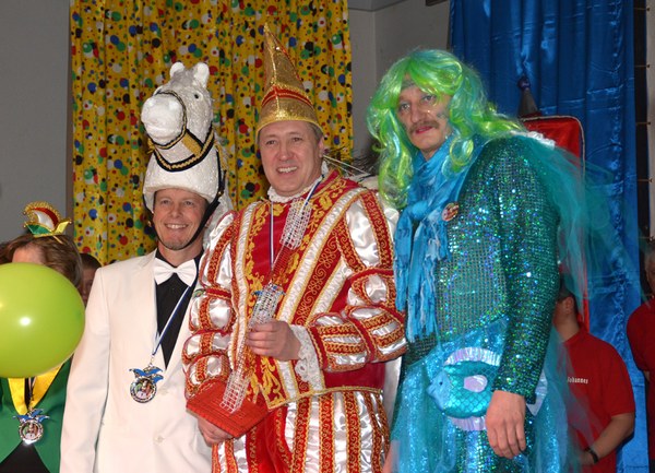 Das Mainflinger Dreigestirn: Schimmel mit Pferdekopf-Mütze, Prinz im rot-goldenen Ornat und Seejungfrau mit grüner Perücke und türkisem Glitzerkleid