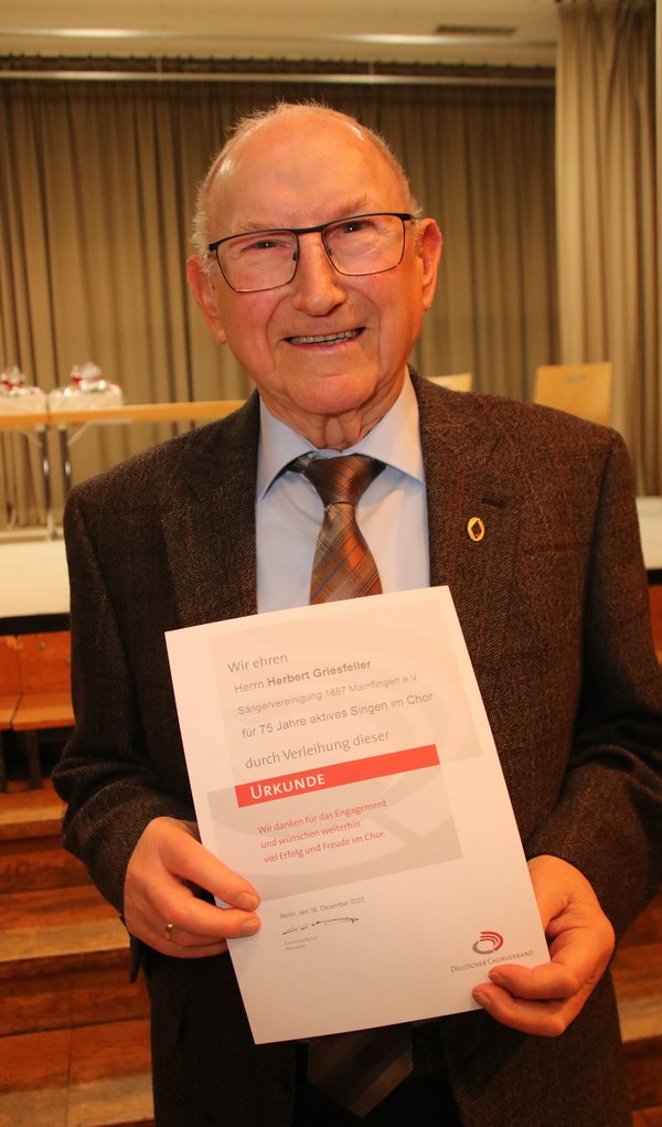 Herbert Griesfeller hält seine Urkunde für 75 Jahre aktives Singen im Chor in den Händen